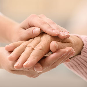 Carer holding hands of an elderly person