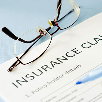 Insurance claim form and reading glasses 