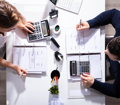 Two accountants working out calculations. The image is illustrating  professional indemnity insurance.
